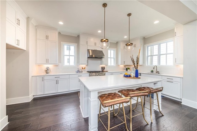 kitchen with white cabinetry, dark hardwood / wood-style floors, a center island, and hanging light fixtures