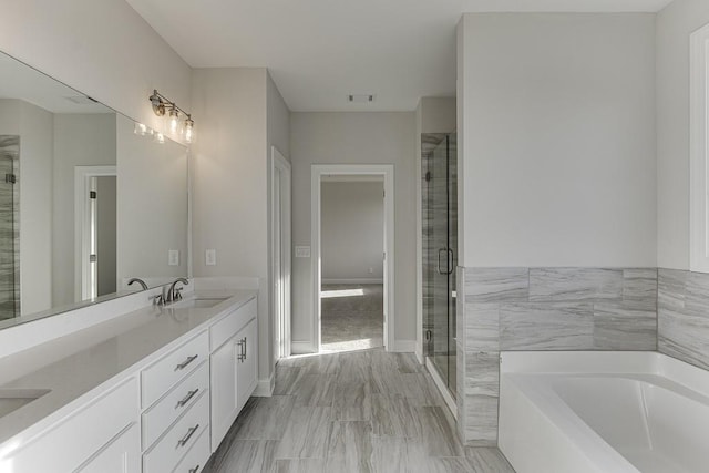 bathroom featuring vanity and independent shower and bath