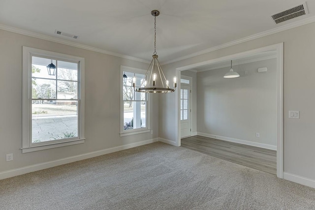 spare room with carpet floors, ornamental molding, and a notable chandelier