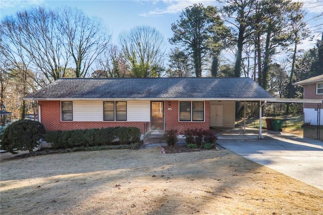 ranch-style house featuring a shingled roof, an attached carport, concrete driveway, and brick siding