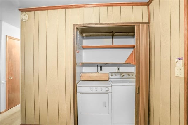 laundry area featuring laundry area, wood walls, and washing machine and clothes dryer