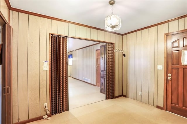 hallway with light carpet, ornamental molding, and visible vents