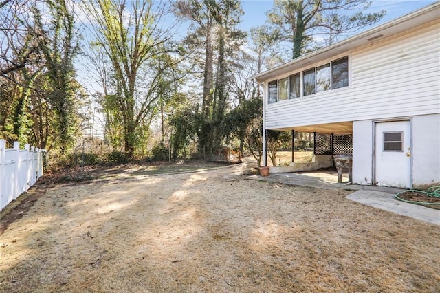 view of yard featuring fence and a carport