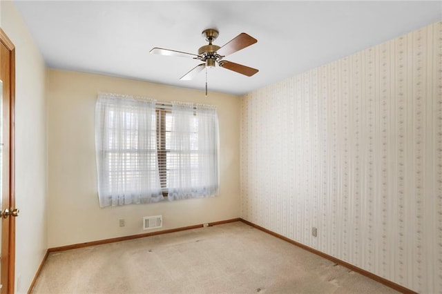 unfurnished room featuring light carpet, wallpapered walls, baseboards, and visible vents