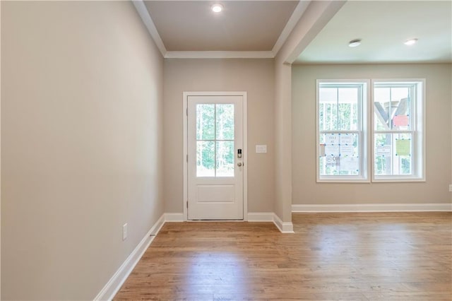 doorway featuring plenty of natural light, light hardwood / wood-style floors, and ornamental molding