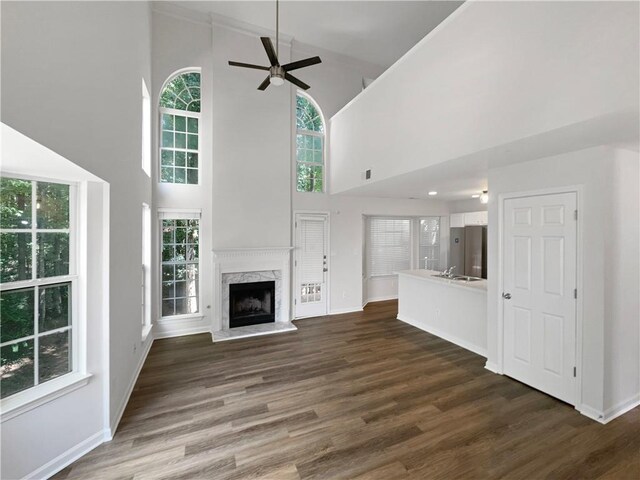 unfurnished living room with a fireplace, a wealth of natural light, high vaulted ceiling, and dark hardwood / wood-style floors