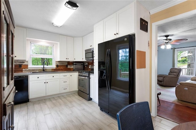 125 Misty Lea Dr, Dallas, GA 30132 - kitchen featuring black appliances, a sink, dark countertops, plenty of natural light, and a textured ceiling