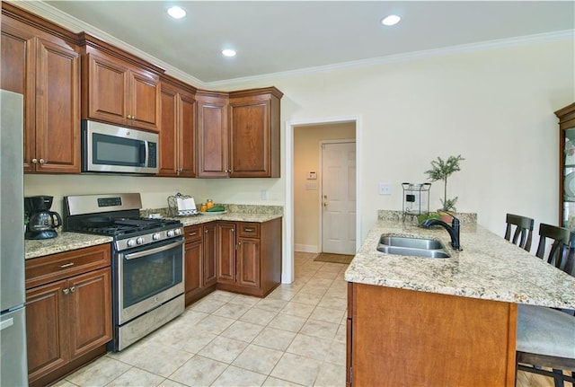 kitchen featuring appliances with stainless steel finishes, a breakfast bar area, kitchen peninsula, and sink