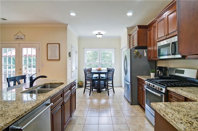 kitchen featuring a wealth of natural light, sink, light tile patterned floors, and stainless steel appliances