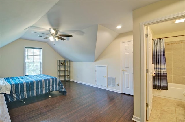 bedroom with ceiling fan, hardwood / wood-style flooring, ensuite bath, and lofted ceiling