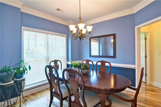 dining room with a wealth of natural light, a chandelier, light hardwood / wood-style flooring, and ornamental molding