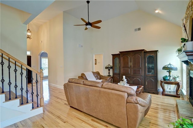 living room with ceiling fan, light hardwood / wood-style flooring, and high vaulted ceiling