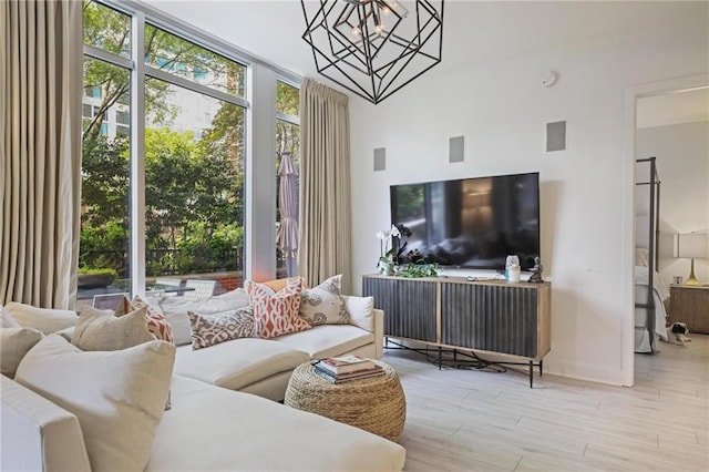 living area with a chandelier, wood finished floors, and baseboards