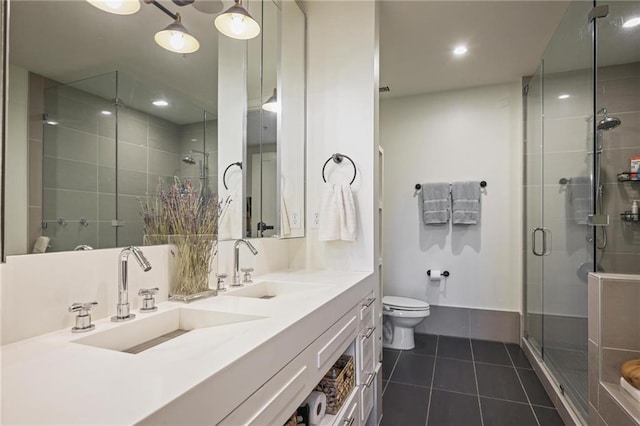 bathroom featuring tile patterned flooring, a stall shower, toilet, double vanity, and recessed lighting