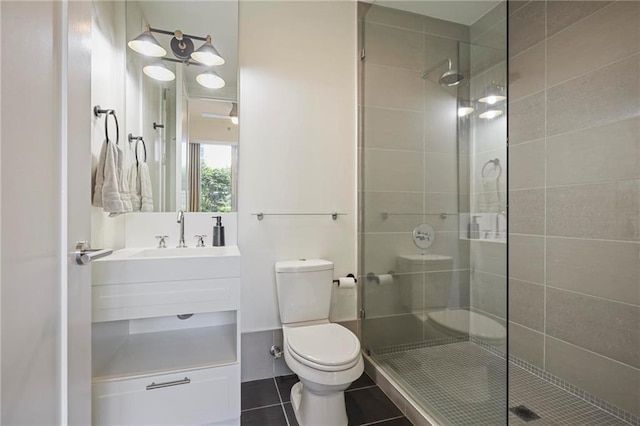 bathroom with a shower stall, toilet, tile patterned floors, and vanity