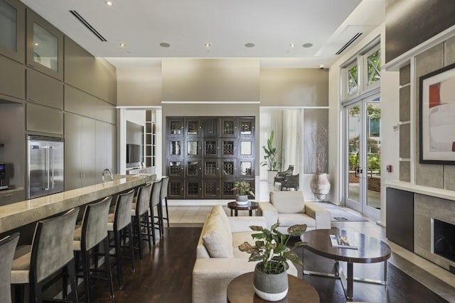 living area with a high ceiling, wood finished floors, and recessed lighting