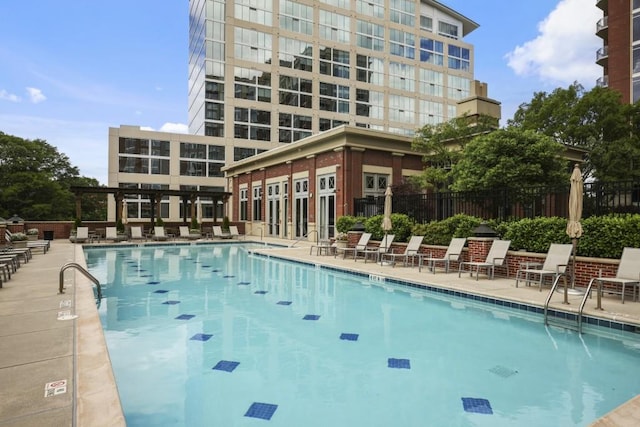 community pool featuring fence and a patio area