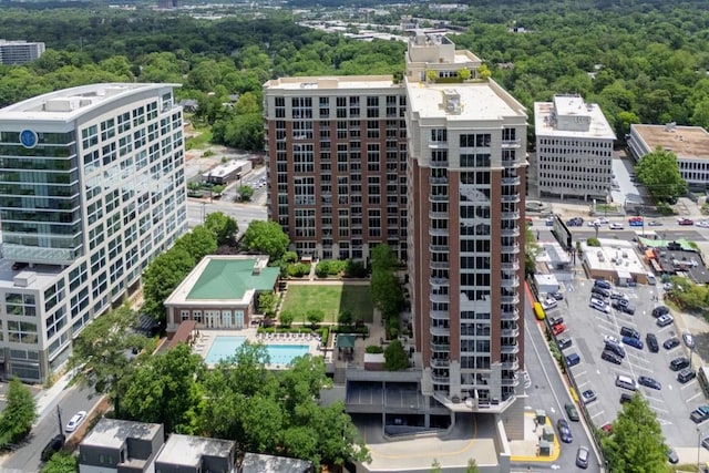 view of urban area featuring a pool and a heavily wooded area