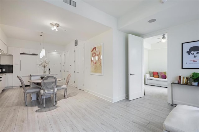dining room featuring light wood finished floors, baseboards, and a ceiling fan
