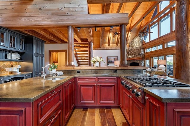 3406 Thunder Pt, Gainesville, GA 30506 - kitchen with a wooden ceiling with exposed beams, stainless steel gas cooktop, reddish brown cabinets, light wood finished floors, and decorative backsplash