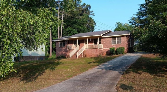 9160 Carr Cir, Covington, GA 30014 - ranch-style home with stairs, a porch, a front yard, asphalt driveway, and brick siding