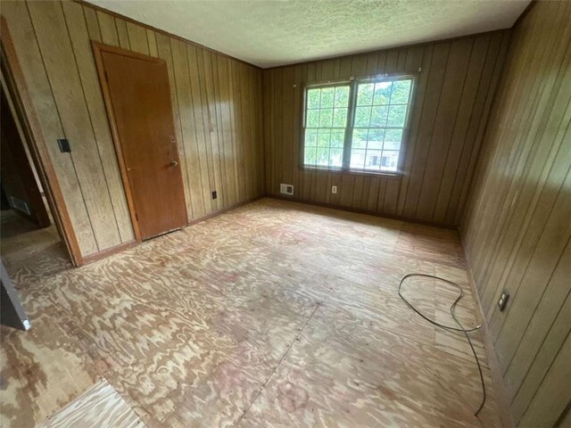 9160 Carr Cir, Covington, GA 30014 - unfurnished bedroom with a textured ceiling and wood walls