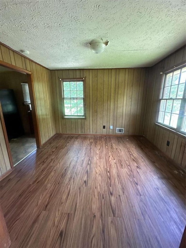 9160 Carr Cir, Covington, GA 30014 - spare room featuring wood finished floors, healthy amount of natural light, a textured ceiling, and wood walls