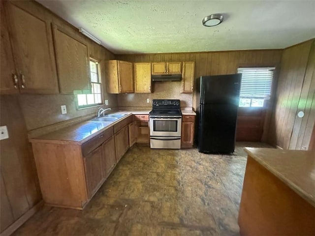 9160 Carr Cir, Covington, GA 30014 - kitchen with freestanding refrigerator, stainless steel range with electric cooktop, under cabinet range hood, plenty of natural light, and wooden walls