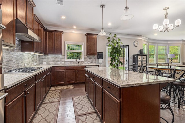 4815 Edgemoore Trce, Cumming, GA 30040 - kitchen with stainless steel gas cooktop, under cabinet range hood, a center island, a sink, and crown molding