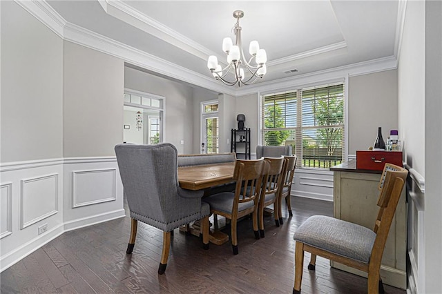 4815 Edgemoore Trce, Cumming, GA 30040 - dining room featuring a chandelier, crown molding, dark wood-style flooring, a tray ceiling, and a wainscoted wall