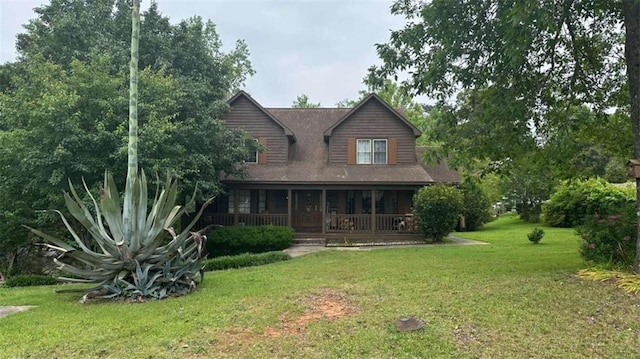 rear view of house featuring covered porch and a lawn