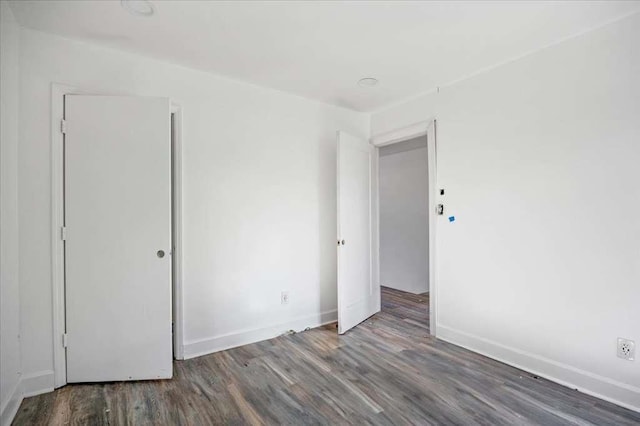 empty room with dark hardwood / wood-style flooring