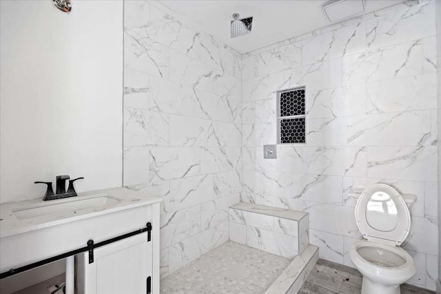 bathroom featuring tile walls, tiled shower, vanity, and toilet