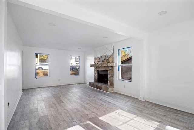 unfurnished living room featuring light wood-type flooring and a fireplace