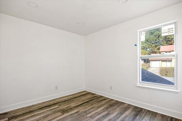 empty room with dark wood-type flooring and a healthy amount of sunlight