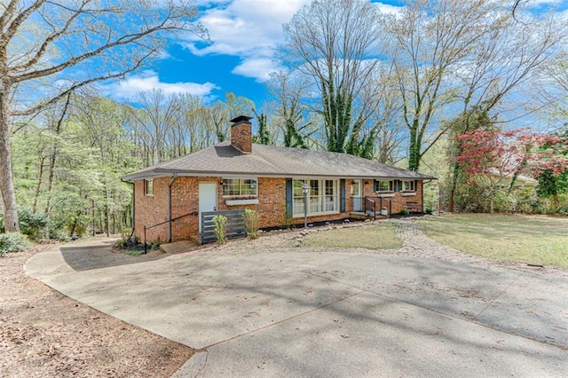 613 Holly Dr, Gainesville, GA 30501 - ranch-style house featuring a chimney, brick siding, a front lawn, driveway, and covered porch