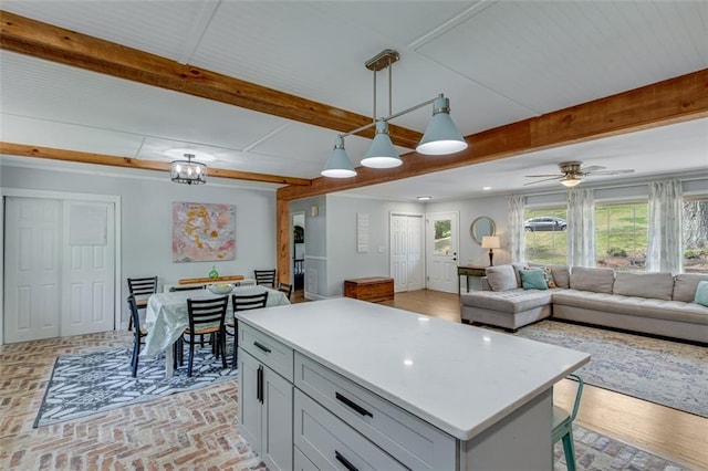 613 Holly Dr, Gainesville, GA 30501 - kitchen featuring light countertops, pendant lighting, a center island, brick floor, and beamed ceiling