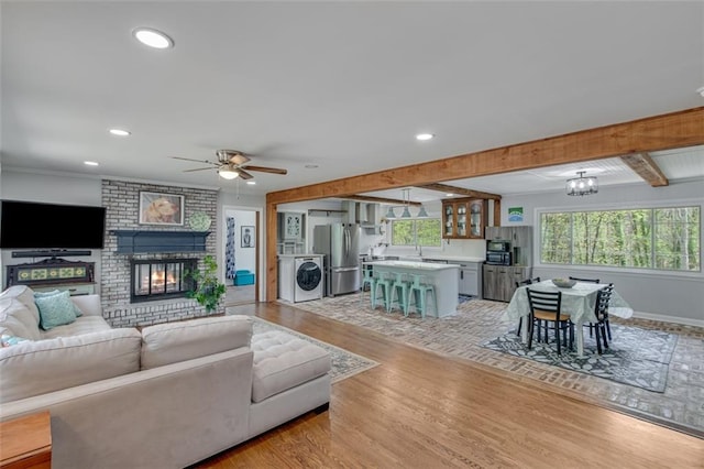 613 Holly Dr, Gainesville, GA 30501 - living area with light wood-style flooring, a fireplace, a ceiling fan, beam ceiling, and washer / dryer