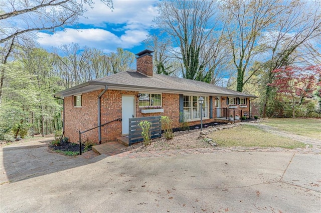613 Holly Dr, Gainesville, GA 30501 - ranch-style house featuring a chimney, a front yard, brick siding, driveway, and covered porch