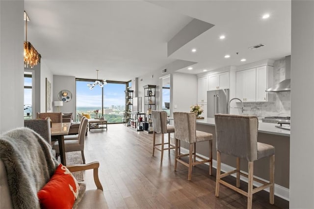 270 17th St NW Unit 2804, Atlanta, GA 30363 - kitchen with wall chimney range hood, high end fridge, wood finished floors, decorative backsplash, and floor to ceiling windows