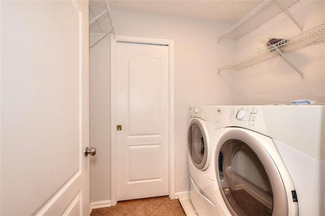 662 Shady Willow Ln, Loganville, GA 30052 - laundry room with washing machine and dryer, light tile patterned floors, and baseboards