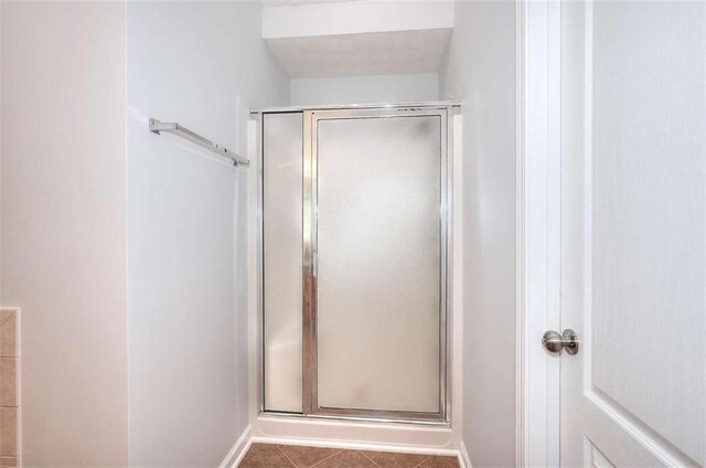 662 Shady Willow Ln, Loganville, GA 30052 - bathroom featuring a stall shower, tile patterned floors, and baseboards