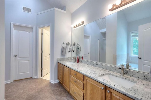 662 Shady Willow Ln, Loganville, GA 30052 - bathroom with double vanity, a stall shower, tile patterned floors, baseboards, and vaulted ceiling