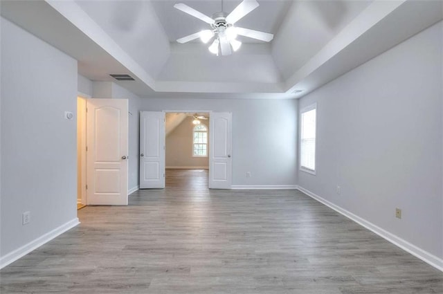662 Shady Willow Ln, Loganville, GA 30052 - spare room featuring ceiling fan, a tray ceiling, wood finished floors, and baseboards