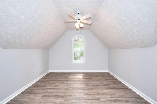 662 Shady Willow Ln, Loganville, GA 30052 - additional living space featuring a textured ceiling, wood finished floors, baseboards, a ceiling fan, and lofted ceiling