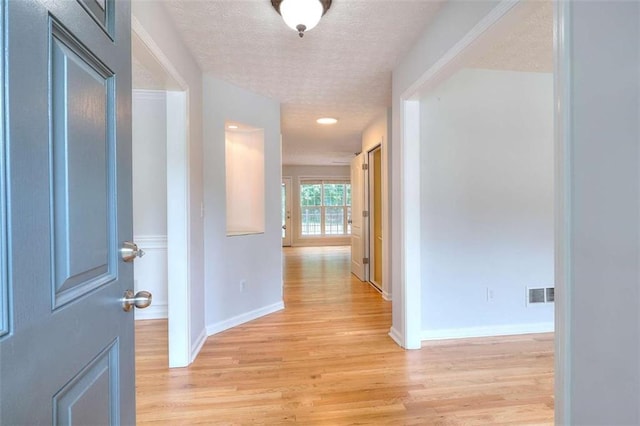 662 Shady Willow Ln, Loganville, GA 30052 - hallway featuring a textured ceiling, light wood-style flooring, and baseboards