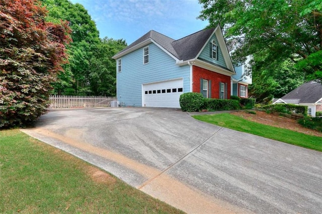 662 Shady Willow Ln, Loganville, GA 30052 - view of side of property with an attached garage, brick siding, driveway, and cooling unit