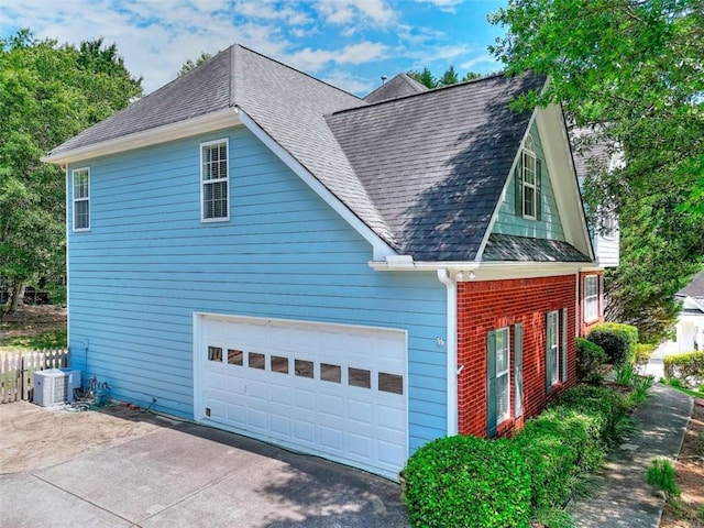 662 Shady Willow Ln, Loganville, GA 30052 - view of home's exterior featuring a garage, roof with shingles, central air condition unit, and driveway