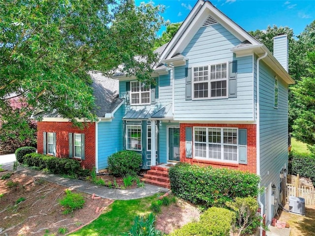 662 Shady Willow Ln, Loganville, GA 30052 - view of front of house with a chimney, central air condition unit, brick siding, and fence