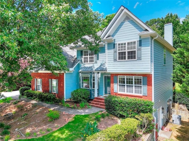 662 Shady Willow Ln, Loganville, GA 30052 - view of front of home with a chimney, brick siding, fence, and cooling unit